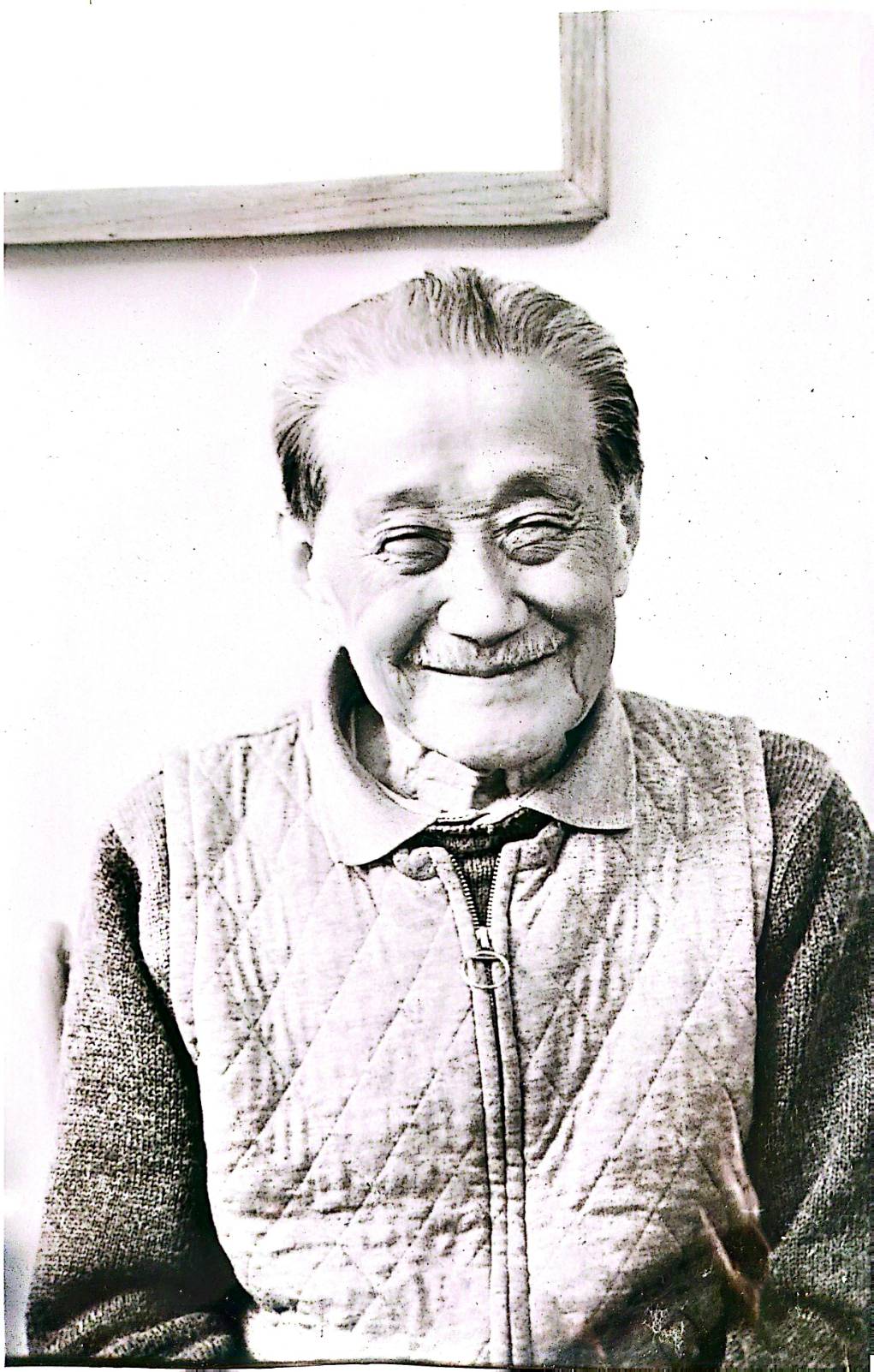 智者的寧靜：丁大師的經典肖像。他閉目微笑，捕捉了幾十年來透過筆墨修煉而成的內心平靜與「禪」的覺知。